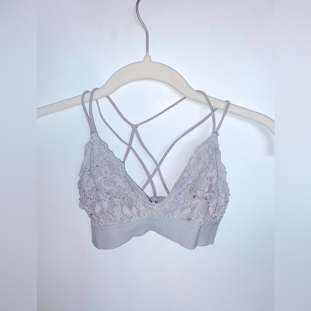 Light grey lacy bralette with cross straps on the back. Size: xs